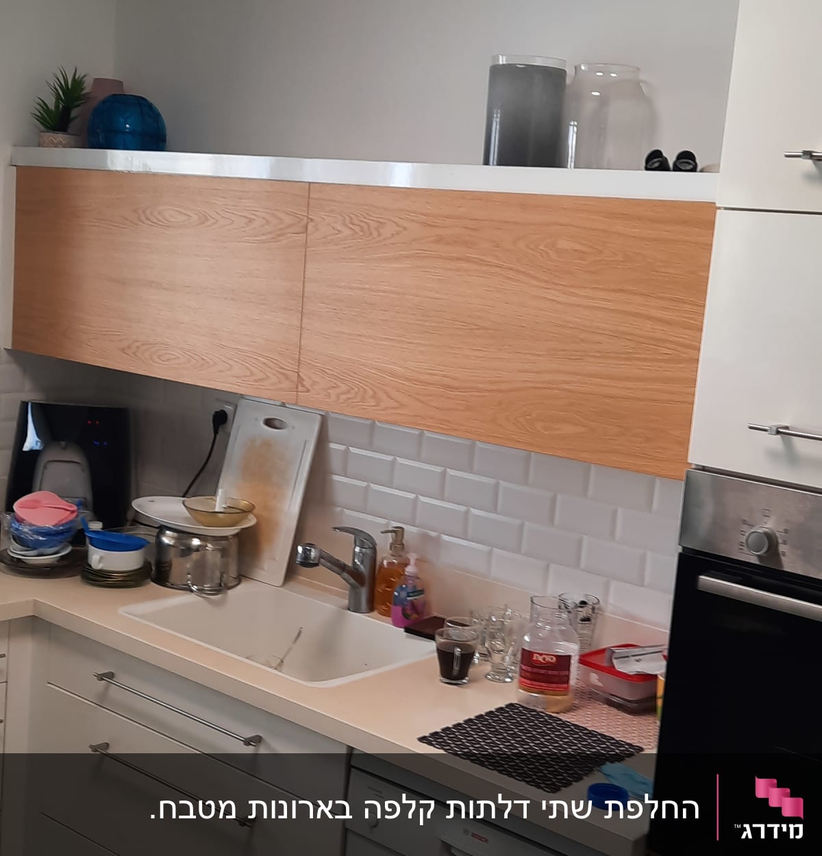 מטבח עם ארונות עץ וכלים על השיש